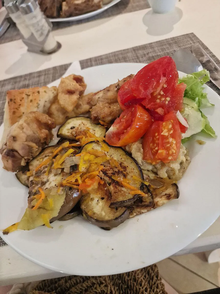 Жаренные на гриле баклажаны, нарезанные помидоры и салат и мясо.