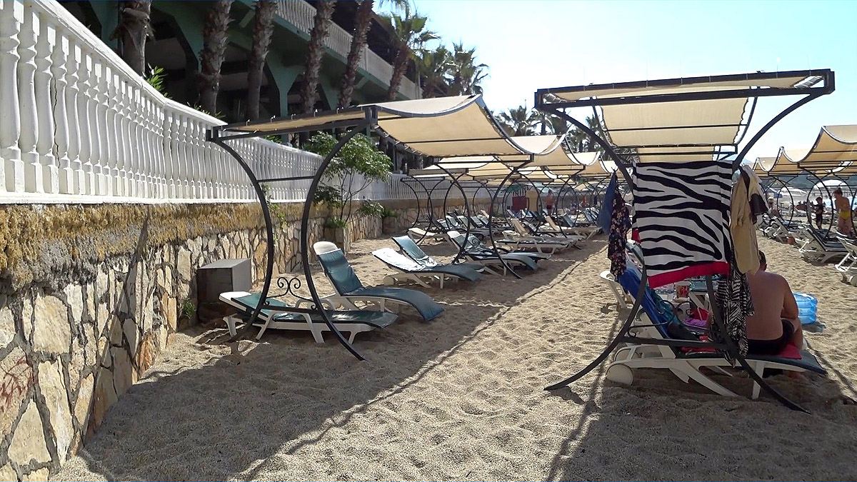 Отель senza garden holiday club Вот так на пляже расположены лежаки с зонтиками.